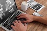 using a laptop while having a coffee